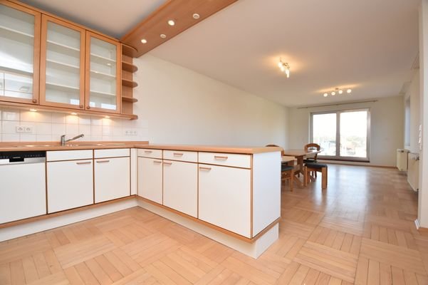 Blick in den Wohnbereich mit der offenen Küche und Balkonzugang
