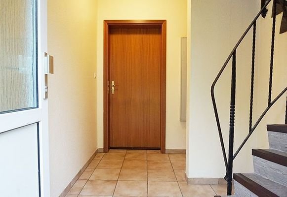 Eingangsflur mit Tür und Treppe zu den Wohnungen